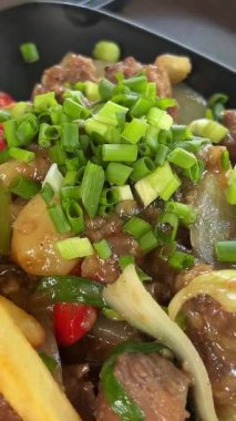 Otantik biftek soslu sığır bifteği sıcak bir tabakta biraz sebze ve patates kızartmasıyla servis edilir. Yüksek kalite 4k görüntü