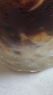 Çikolatalı dondurmalı kahve, çikolatalı dondurma kokteyli. Yoğunlaştırılmış süt ve buzlu Vietnam kahvesi, muz dilimleri bardağı süsler, karıştırır.