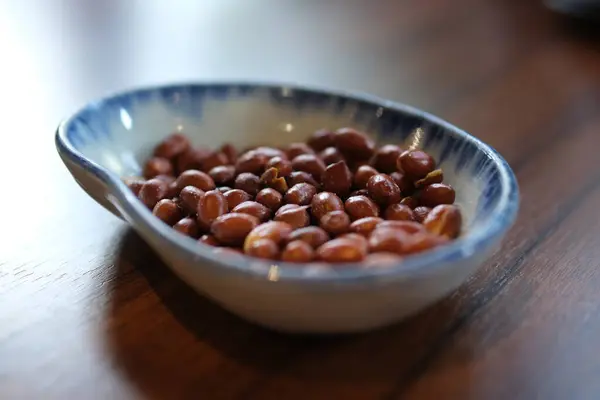 Koyu beton arka planda seramik kasede lezzetli besleyici fıstık. Yüksek kalite 