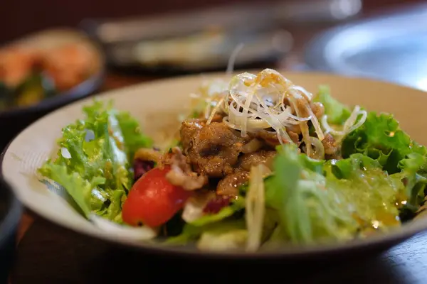 Baharatlı sığır eti dilimleri havuç, domates, salatalık, maydanoz, turp ve salata yapraklı ıspanak, roket, eski ahşap masada kırmızı yakut bahçesi. Yüksek kalite 