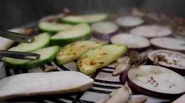 Kabak ya da yeşil sebze ilikleri ateşte kızartılır. Aşçı, her tarafta yemek pişirildiğinden emin olmak için kabak dilimlerini çeviriyor. Yüksek kalite 4k görüntü