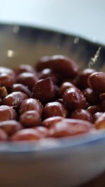 Koyu beton arka planda seramik kasede lezzetli besleyici fıstık. Yüksek kalite 