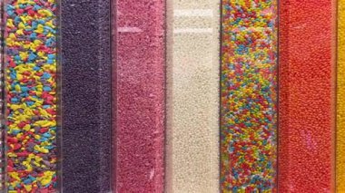 Makro, bir tepsi yumuşak fıçı şeklindeki, pembe ve beyaz şekerlemeli şekerleme yığınının yavaş çekimini yapıyor. Yüksek kalite 4k görüntü