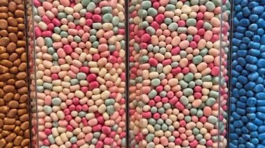 Makro, bir tepsi yumuşak fıçı şeklindeki, pembe ve beyaz şekerlemeli şekerleme yığınının yavaş çekimini yapıyor. Yüksek kalite 4k görüntü