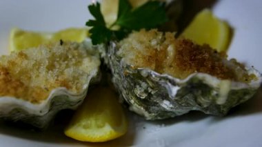 Kabuklu kızarmış istiridye, sarımsaklı limon ve siyah desenli arkaplanda limon. Üst Manzara. Dark Stone 'da sağlıklı gurme yemekleri. Lüks Restoran 'da birinci sınıf deniz yemeği. Yüksek kalite 4k görüntü