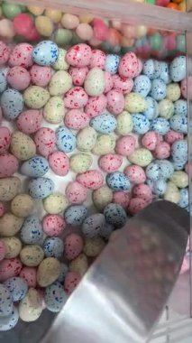 Paskalya Kolombiya pastası kırıntıları beyaz yüzeyde benekli mini Paskalya yumurtalarıyla saçılmış. Yüksek kaliteli FullHD görüntüler