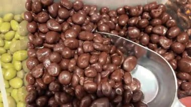 Çikolata kaplı fıstıklar, daireler çizerek dönüyorlar. Çikolatalı fındık, Turning. çikolata arkaplanı. Çikolata kaplı fındık. Yüksek kalite 4k görüntü