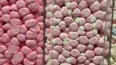 Dönüşümlü pembe arka planda iki renkli mini marşmelov yakın plan. Yüksek kalite 4k görüntü