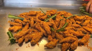 Renkli Arkaplanda Kızarmış Tavuk Parçalarının Yavaş Hareketi. Turntable 'da dönen dumanlı taze çıtır tavuk. Makro atış. Yüksek kalite 4k görüntü