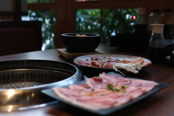 Çin baharatlı güveç çorbası. Bir restorandaki masada çiğ et slaytlarıyla tabak. Tipik sıcak tencere bitkisel mutfak ve Tayvan-Dan 'de taze ve lezzetli yemekler. Yüksek kalite