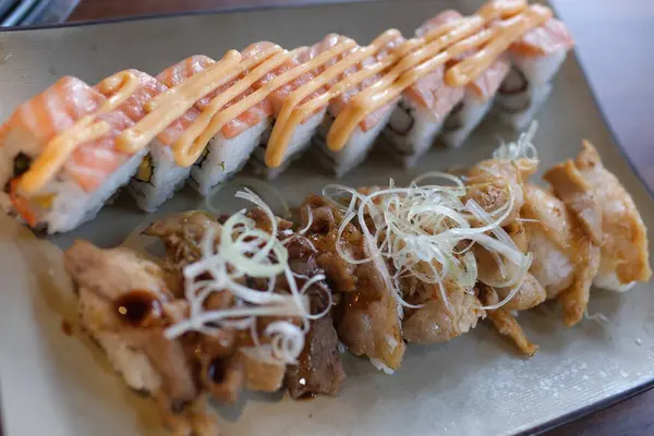 Şef siyah arka planda Japon somon suşisini yakıyor. Yüksek kalite 4k görüntü