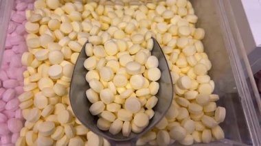 Erkeğin elinin renkli şekerlemeleri kepçeyle aldığı yakın plan çekimler. Bir sürü farklı şekerlemeyle dolu bir kutu. Yüksek kalite 4k görüntü