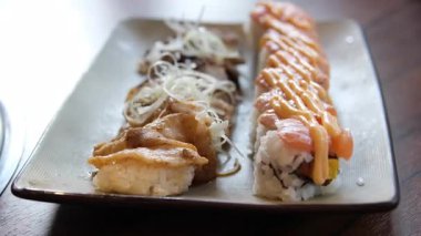 Şef siyah arka planda Japon somon suşisini yakıyor. Yüksek kalite 4k görüntü