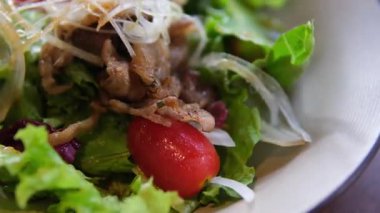 Bir kase kızarmış tavuk salatası, üzerine de kızarmış ekmek ve vişneli domates. Yüksek kalite 4k görüntü