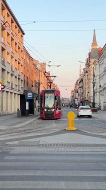 Soğuk bir günde yaya geçidinden geçen insanlar Polonya Katowice 06.20.25 'ten geçen bir tramvay.