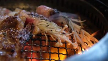 Domuz pastırması ve et ızgarasına sarılı Enoki mantarları yakın plan..