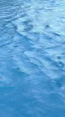 Açık mavi arkaplanda su yüzeyinin süper yavaş çekimi. Yüksek hızlı sinema kamerası, 1000 fps. Yüksek kalite 4k görüntü