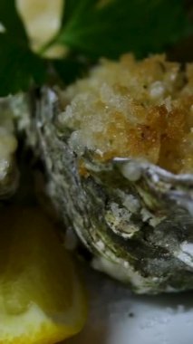 Kabuklu kızarmış istiridye, sarımsaklı limon ve siyah desenli arkaplanda limon. Üst Manzara. Dark Stone 'da sağlıklı gurme yemekleri. Lüks Restoran 'da birinci sınıf deniz yemeği. Yüksek kalite 4k görüntü