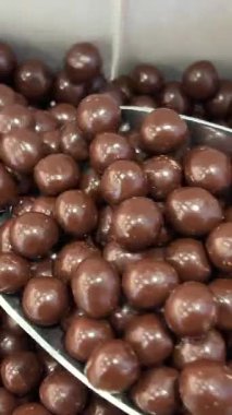 Kaba bir çuval bezi üzerinde çikolata soslu toplar. Fıstıklı tatlı, yuvarlak şekerler. Makro. Dolly vurdu. Yüksek kalite 4k görüntü