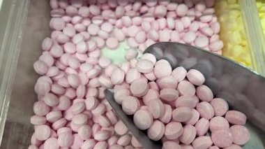 Şeker kepçesi dolusu yumuşak fıçı şeklinde, pembe ve beyaz şekerleme kalıpları, bir tabakta. Yüksek kalite 4k görüntü