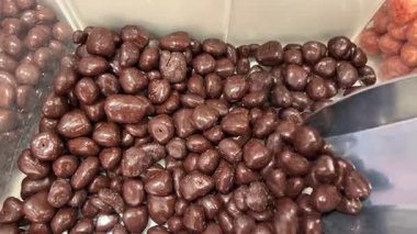 Çikolata kaplı fıstıklar, daireler çizerek dönüyorlar. Çikolatalı fındık, Turning. çikolata arkaplanı. Çikolata kaplı fındık. Yüksek kalite 4k görüntü