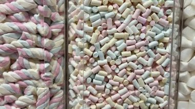 Dönüşümlü pembe arka planda iki renkli mini marşmelov yakın plan. Yüksek kalite 4k görüntü