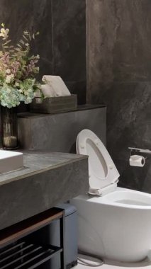 Modern klasik stil gri duvarlı banyo 3D resimleme animasyonu ahşap zemin ve lavabo tezgahı, mumla süslenmiş altın yuvarlak ayna. Yüksek kalite 4k görüntü