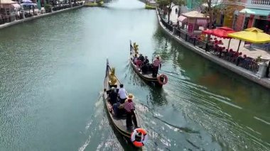 Nehir kenarındaki renkli oyuncak evlerinde yüzen Grand World gondolcuları boş Vietnam şehri Phu Quoc Adası 07.24.2025