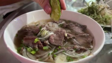 Çorbanın içine limon suyu sıkıp küçük bir kase Çin eriştesi çorbası çorbası al. Yüksek kalite 4k görüntü