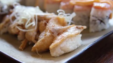 Suşi ayna masasında döner. Yemeye hazır aperatif Japon suşi dürümleri yakın planda dönüyor. Taze unagi suşi ve somon ve Philadelphia peynirli rulo. Yüksek kalite 4k görüntü