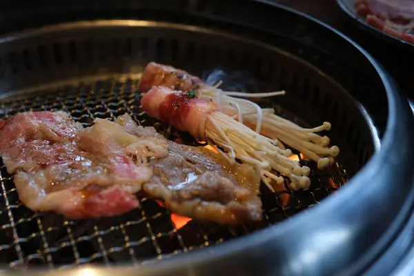 Smokey Hot BBQ 'da domuz sosisi ve sebze şiş kebap ile biftek çeviren şef.