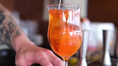 Barmen kokteyl yapımında kullanılan malzemeleri ölçmek için jigger kullanır ve yavaş çekimde sallanan sıvıları yakın çekime döker. Barmenler için profesyonel eğitim. Yüksek kalite 4k görüntü