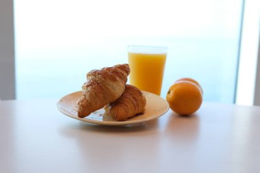 Kahvaltının yanında kahve, portakal suyu, kruvasan ve mısır gevreği var. Yüksek kalite 4k görüntü