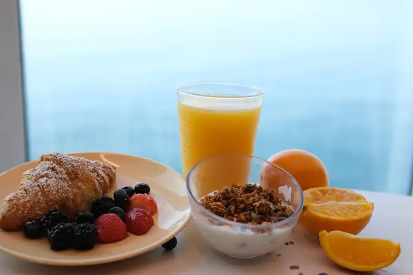 Ahududu ve böğürtlenli Yunan yoğurdu, bir kâseden kaşıkla kepçelenmiş, yakın plan, üst manzara. Yüksek kalite 4k görüntü