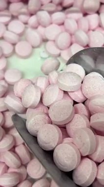 Şeker kepçesi dolusu yumuşak fıçı şeklinde, pembe ve beyaz şekerleme kalıpları, bir tabakta. Yüksek kalite 4k görüntü