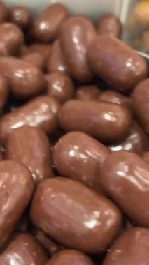 Çikolatalı badem, daire şeklinde dönüş. Beyaz çikolatalı badem, siyah ve sütlü çikolata, Turning. Çikolata kaplı badem. Yüksek kalite 4k görüntü