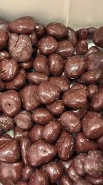 Çikolata kaplı fıstıklar, daireler çizerek dönüyorlar. Çikolatalı fındık, Turning. çikolata arkaplanı. Çikolata kaplı fındık. Yüksek kalite 4k görüntü