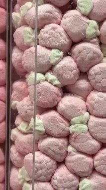 Dönüşümlü pembe arka planda iki renkli mini marşmelov yakın plan. Yüksek kalite 4k görüntü