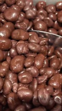 Çikolata kaplı fıstıklar, daireler çizerek dönüyorlar. Çikolatalı fındık, Turning. çikolata arkaplanı. Çikolata kaplı fındık. Yüksek kalite 4k görüntü