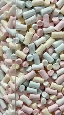 Dönüşümlü pembe arka planda iki renkli mini marşmelov yakın plan. Yüksek kalite 4k görüntü