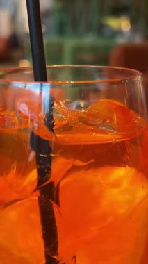 Garson dikkatle iki kokteyl bardağına buz küpleriyle portakal süslemesi yapıyor. Yüksek kalite 4k görüntü