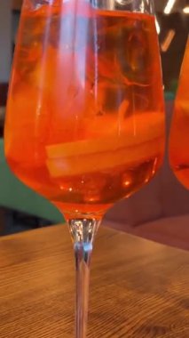 Tahta masa, Coco ve Rose reçelli cheesecake ve iki bardak Aperol. Yüksek kalite 4k görüntü