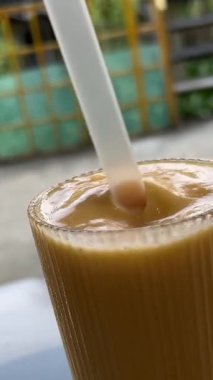 Plastik bardaktan pipetçi kızın içinden iç. Portakal kamışından plastik bardaktan milkshake iç. Yakın plan. Yüksek kalite 4k görüntü
