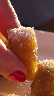 Tanınmayan bir kadın Türk hazzını bir fincan tabaktan alıyor ve doğuya özgü tatlılar yiyor, sokak kafeteryasında bir bardak Türk Armudu 'nda siyah çay ile renkli tatlılar yiyor, insanlar yürüyor.