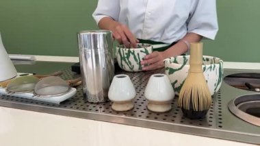 Geleneksel Japon töreninde güzel yeşil çay tozu çırpan bir kadının yaptığı kibrit çayı. Sakinleşme ritüeli denge, farkındalık ve doğal tatlara odaklandı. .