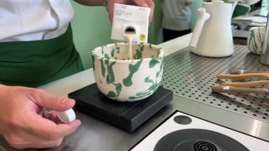 Geleneksel Japon töreninde güzel yeşil çay tozu çırpan bir kadının yaptığı kibrit çayı. Sakinleşme ritüeli denge, farkındalık ve doğal tatlara odaklandı. .