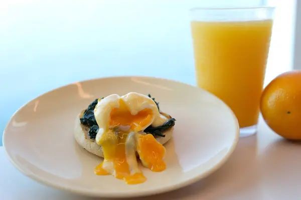 Sağlıklı Kahvaltıda Ekmek Ekmek Tostu ve Yeşil Salata, Avokado ve Bezelye ile Çırpılmış Yumurta. Arkaplanda Portakal Suyu ve Portakal Dilimleri. Yüksek kalite fotoğraf