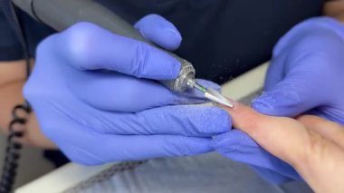 Bir manikürcü tırnağı keser. Güzellik salonunda çivi bakım prosedürü. Yüksek kalite 4k görüntü