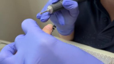 Jel ojeyi kurutmak için modaya uygun UV öncü lamba, ultraviyole kurutma makinesinin altındaki kadın eli, kırmızı lambayla kurutulan renkli tırnaklar, manikür ve güzellik endüstrisi konsepti.