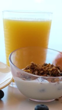 Yulaflar, parlak bir mutfak tezgahındaki elma ve böğürtlen gibi renkli meyve karışımlarını güçlendiren bir süt yağmuruyla kaplanıyor. Yüksek kalite 4k görüntü